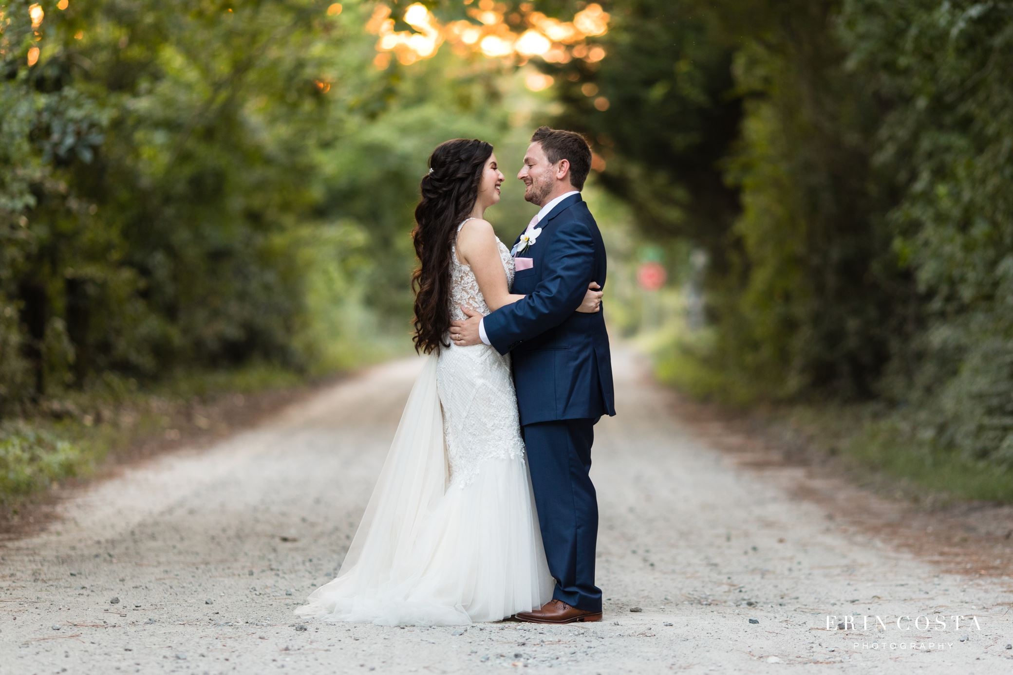 Сouple wearing a white gown and a black suit on the road