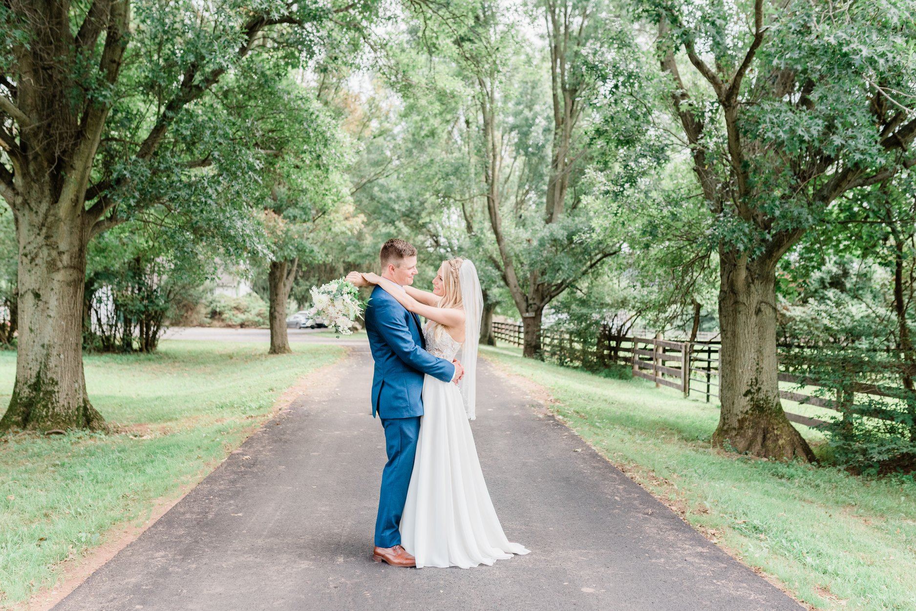 Сouple wearing a white gown and a blue suit on the road