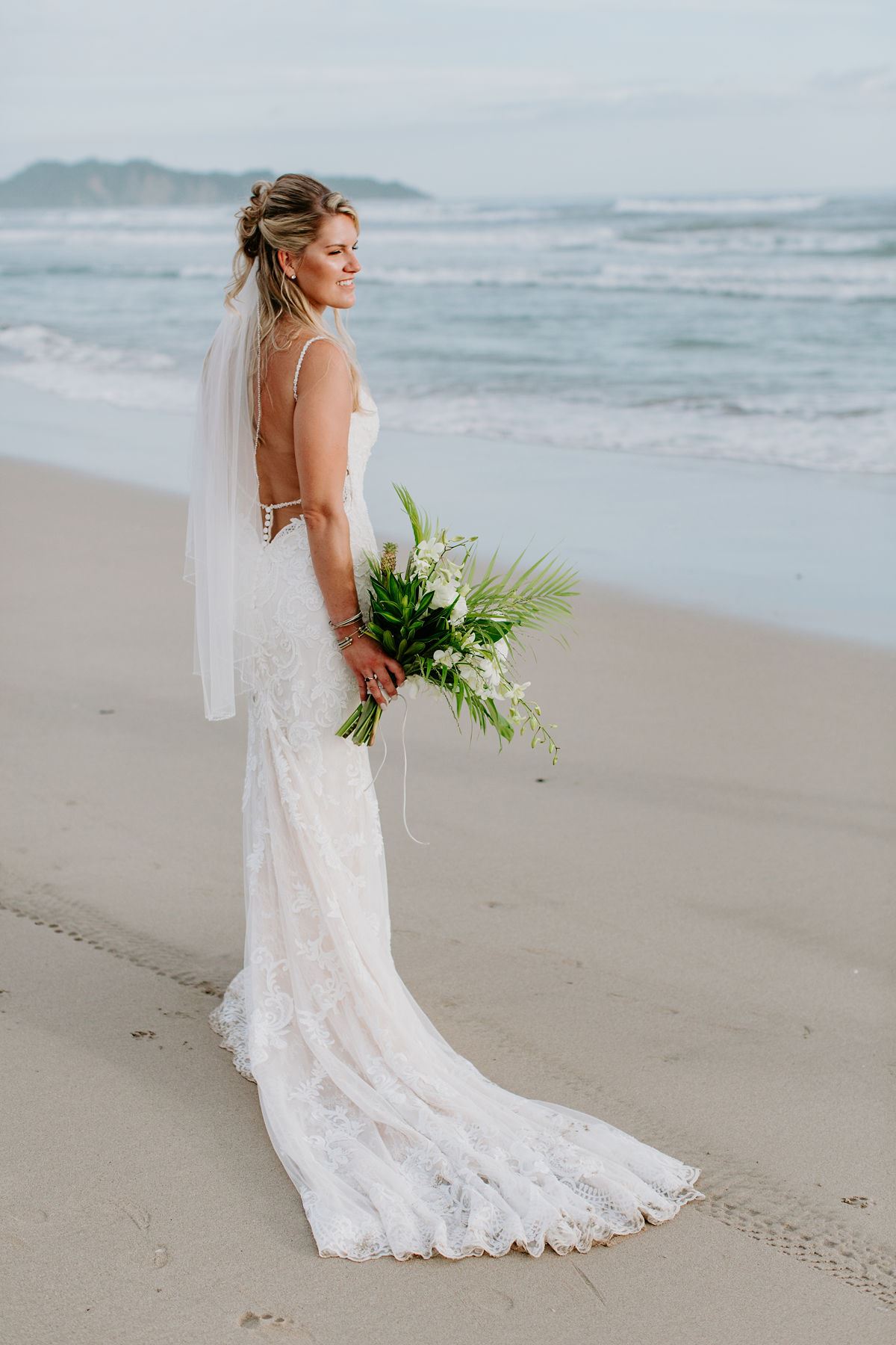 Model wearing a bridal gown on the beach