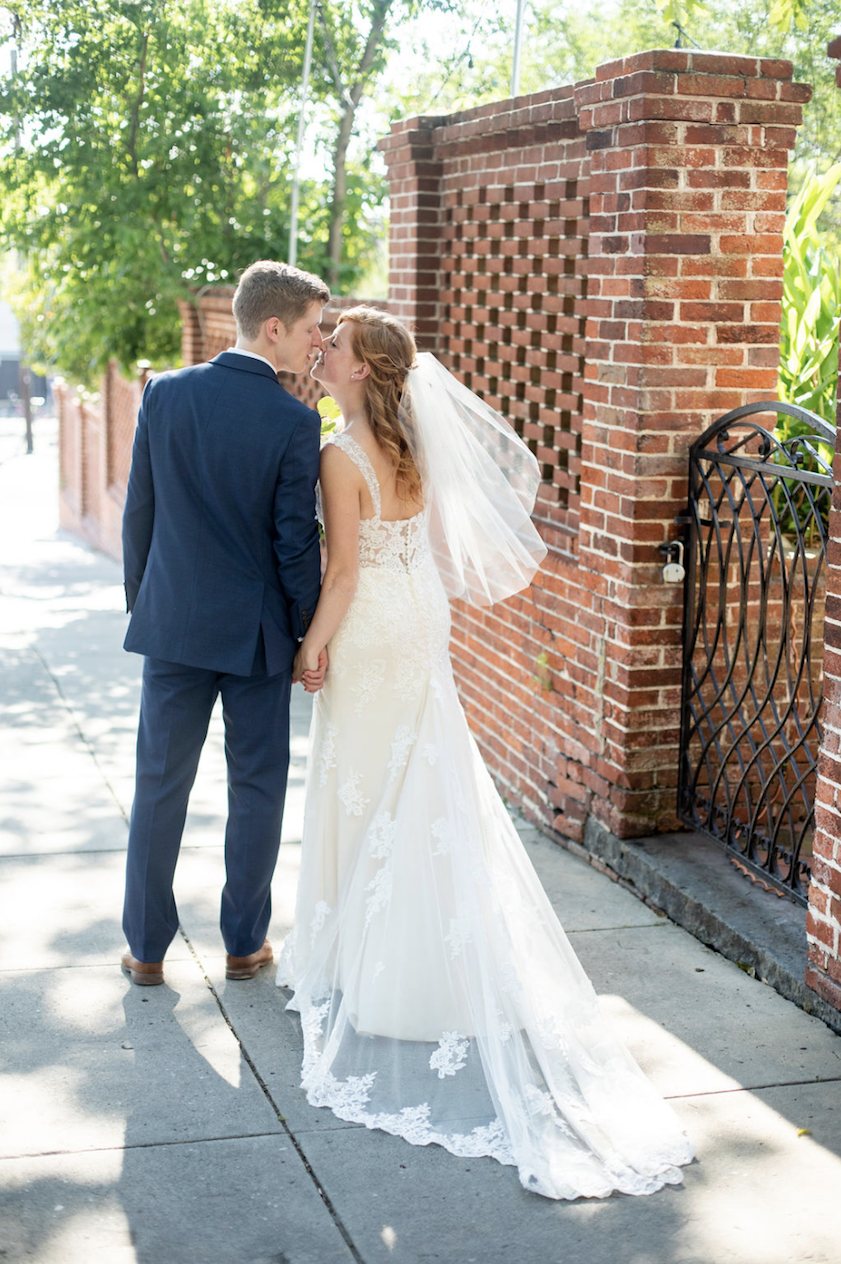 Сouple wearing a white gown and a black suit on the street