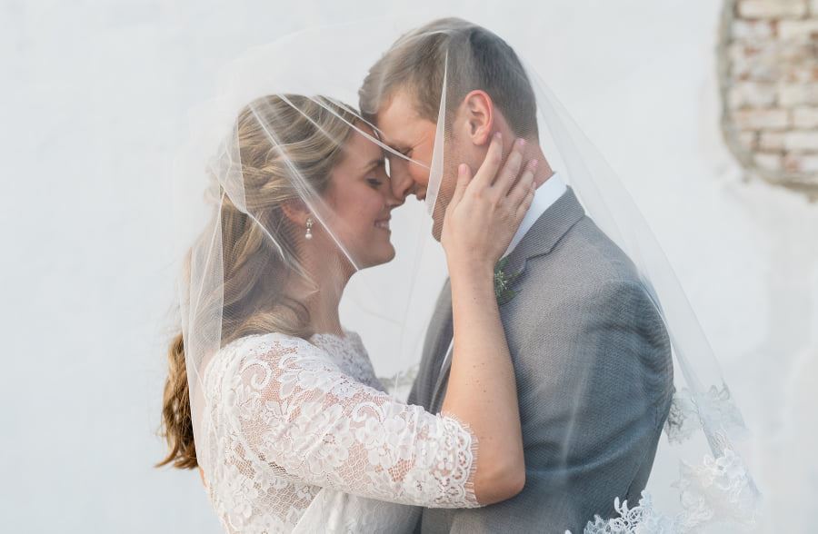 Сouple wearing a white gown and a gray suit
