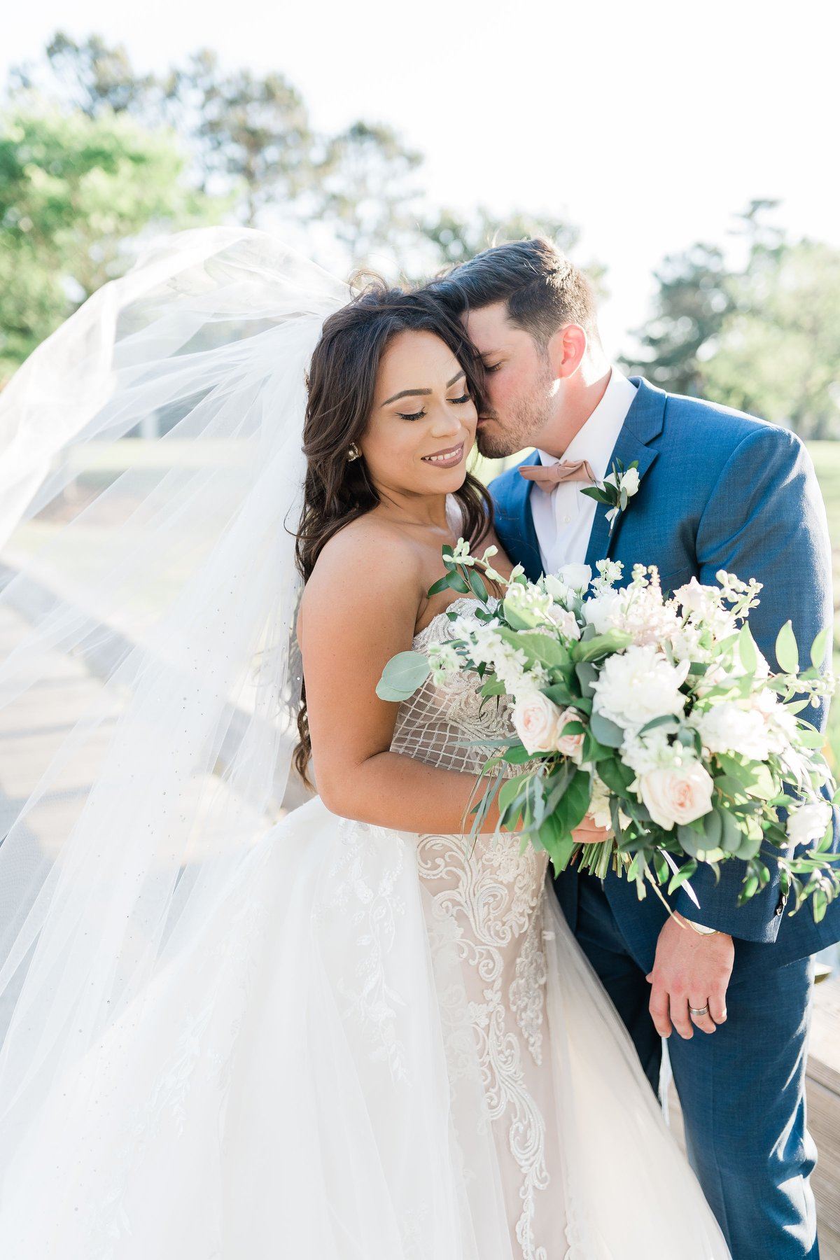 Сouple wearing a white gown and a blue suit with a flowers