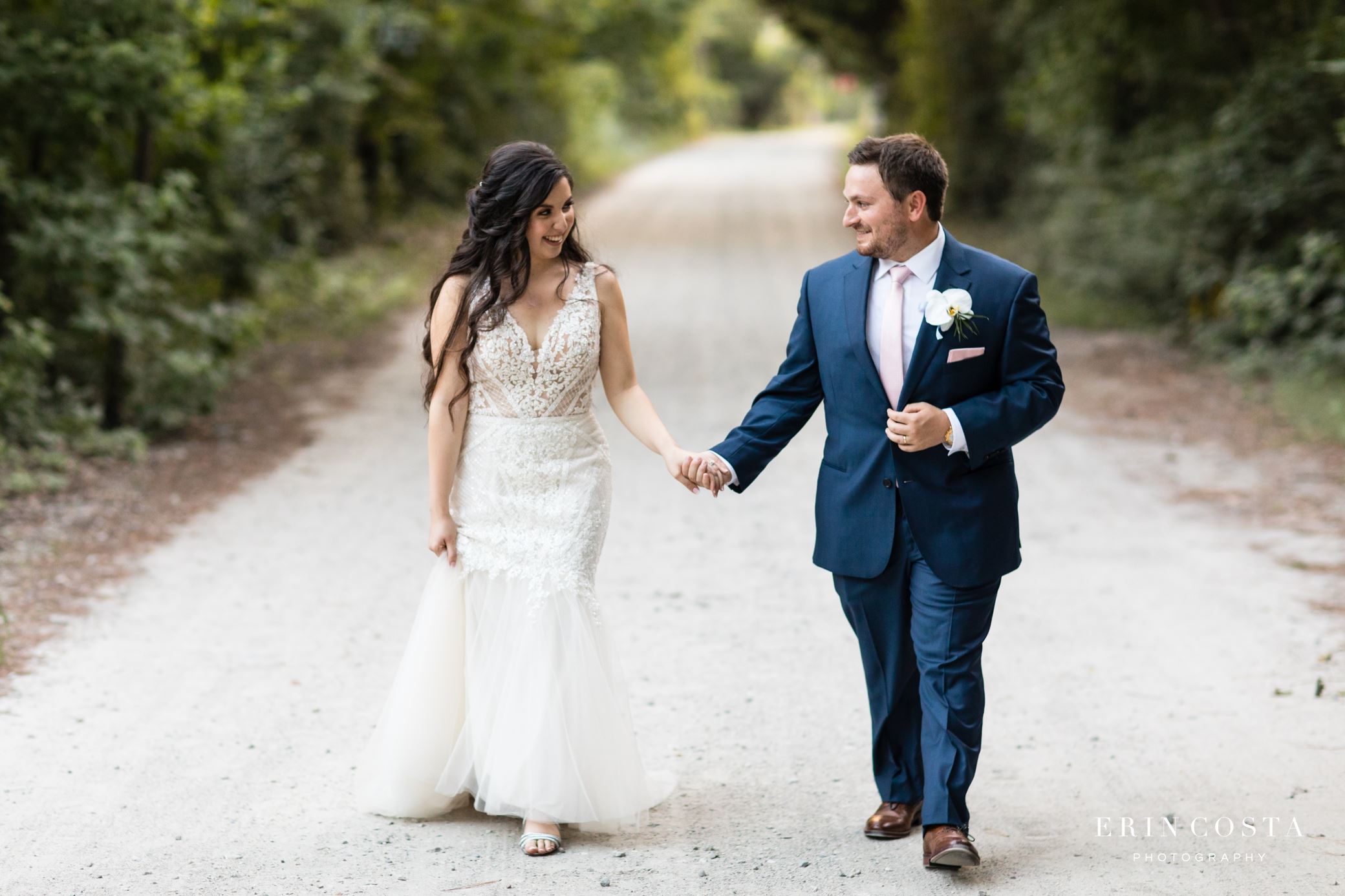 Сouple wearing a white gown and a black suit on the road