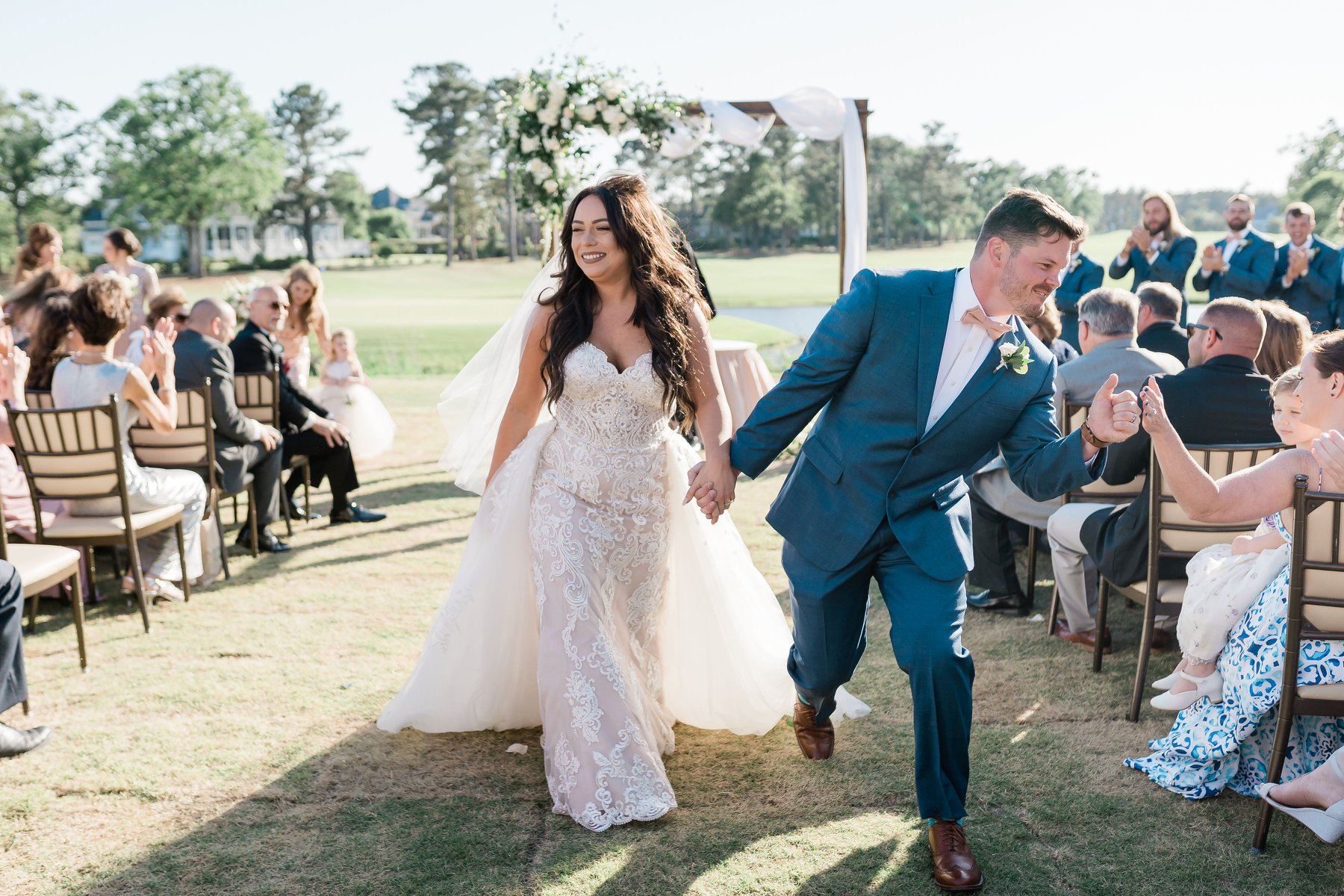 Сouple wearing a white gown and a blue suit with a friends